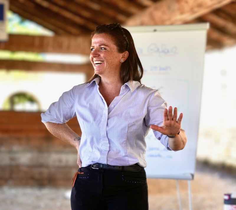 Elsa souriante lors d’une séance d’enseignement devant un tableau